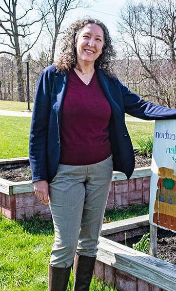 Julie Smith is standing next to a garden bed